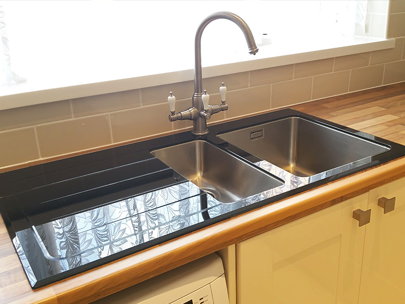 Close Up Of Stainless Steel Tap And Under Set Sink In Black